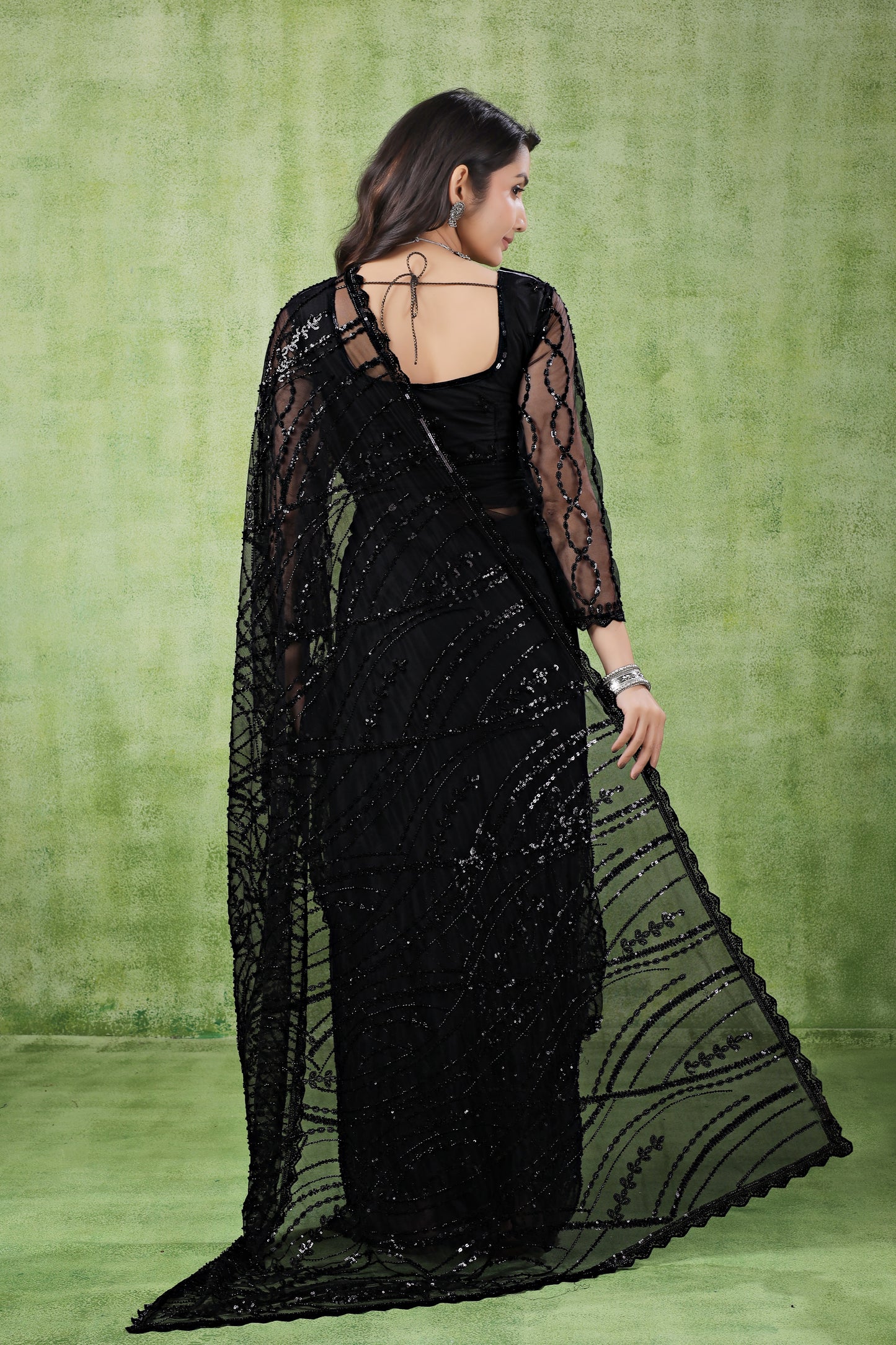 Kanyaari black net handwork saree with intricate embroidery and unstitched blouse, draped elegantly on a model.