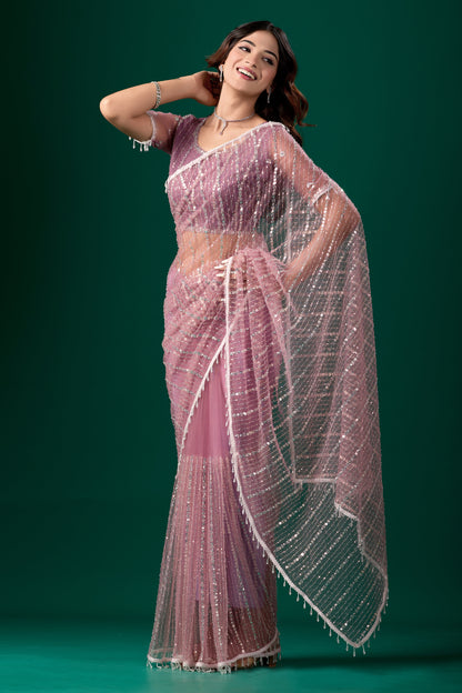 Purple net saree with cutdana work and latkan details, paired with an unstitched blouse from Kanyaari.