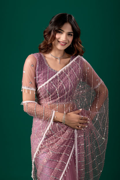 Purple net saree with cutdana work and latkan details, paired with an unstitched blouse by Kanyaari.