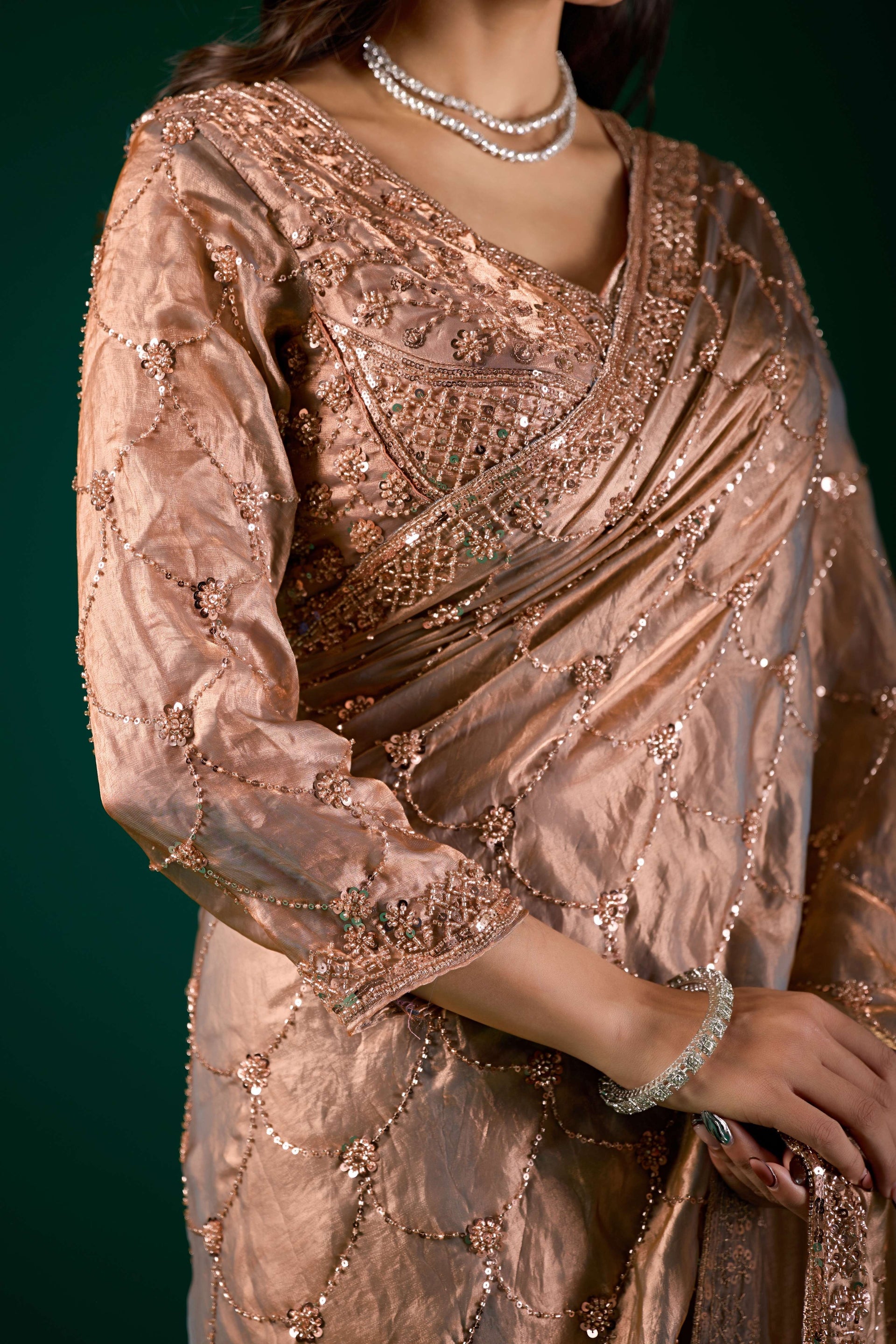 Elegant silk saree by Kanyaari featuring rose gold cutdana work and intricate gold embroidery.