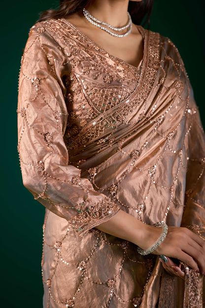 Elegant silk saree by Kanyaari featuring rose gold cutdana work and intricate gold embroidery.