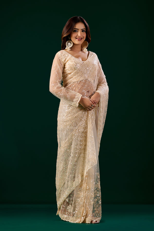 Cream embroidered saree with heavy cutdana work, stylish net fabric by Kanyaari, featuring intricate embroidery and elegant design.