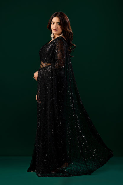 Kanyaari black net handwork saree with intricate embroidery and unstitched blouse, draped elegantly on a model.