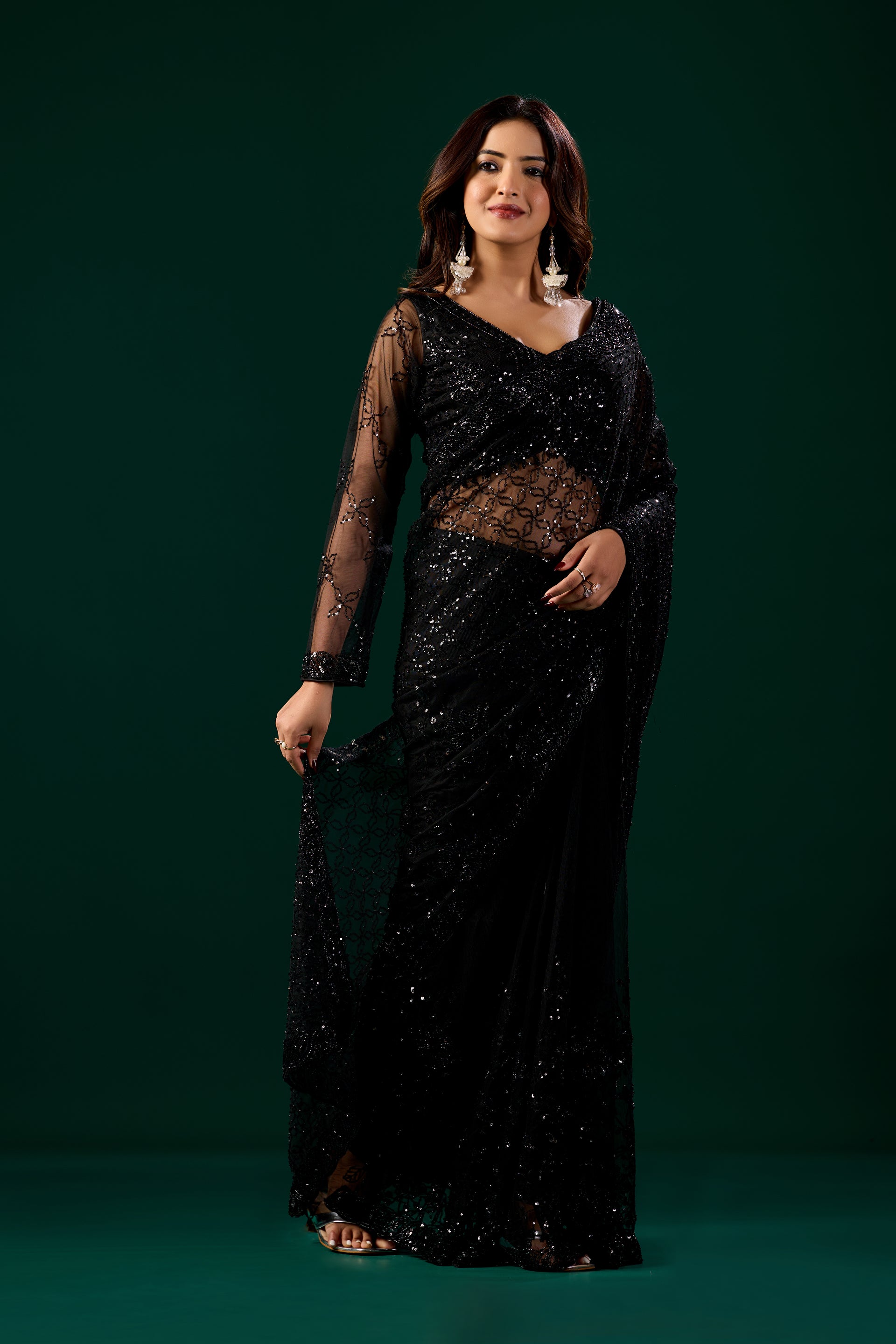 Kanyaari black net saree with intricate handwork and unstitched blouse, showcasing elegant drape and detailed embroidery.