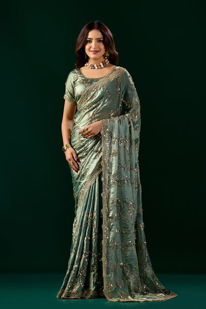 Kanyaari premium green silk saree with rose gold cutdana work, elegant nakhrali design and intricate detailing.