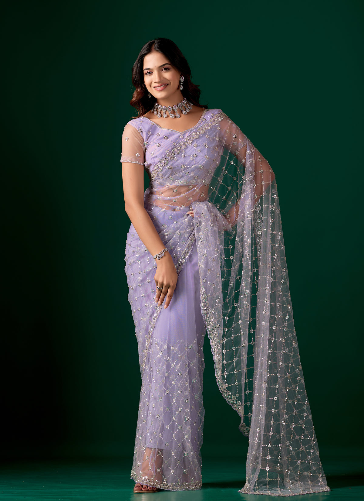 Purple net saree with cutdana work from Kanyaari featuring elegant draping and intricate embroidery for festive occasions.