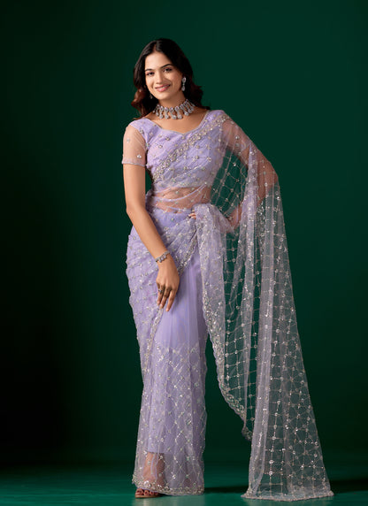 Purple net saree with cutdana work from Kanyaari featuring elegant draping and intricate embroidery for festive occasions.