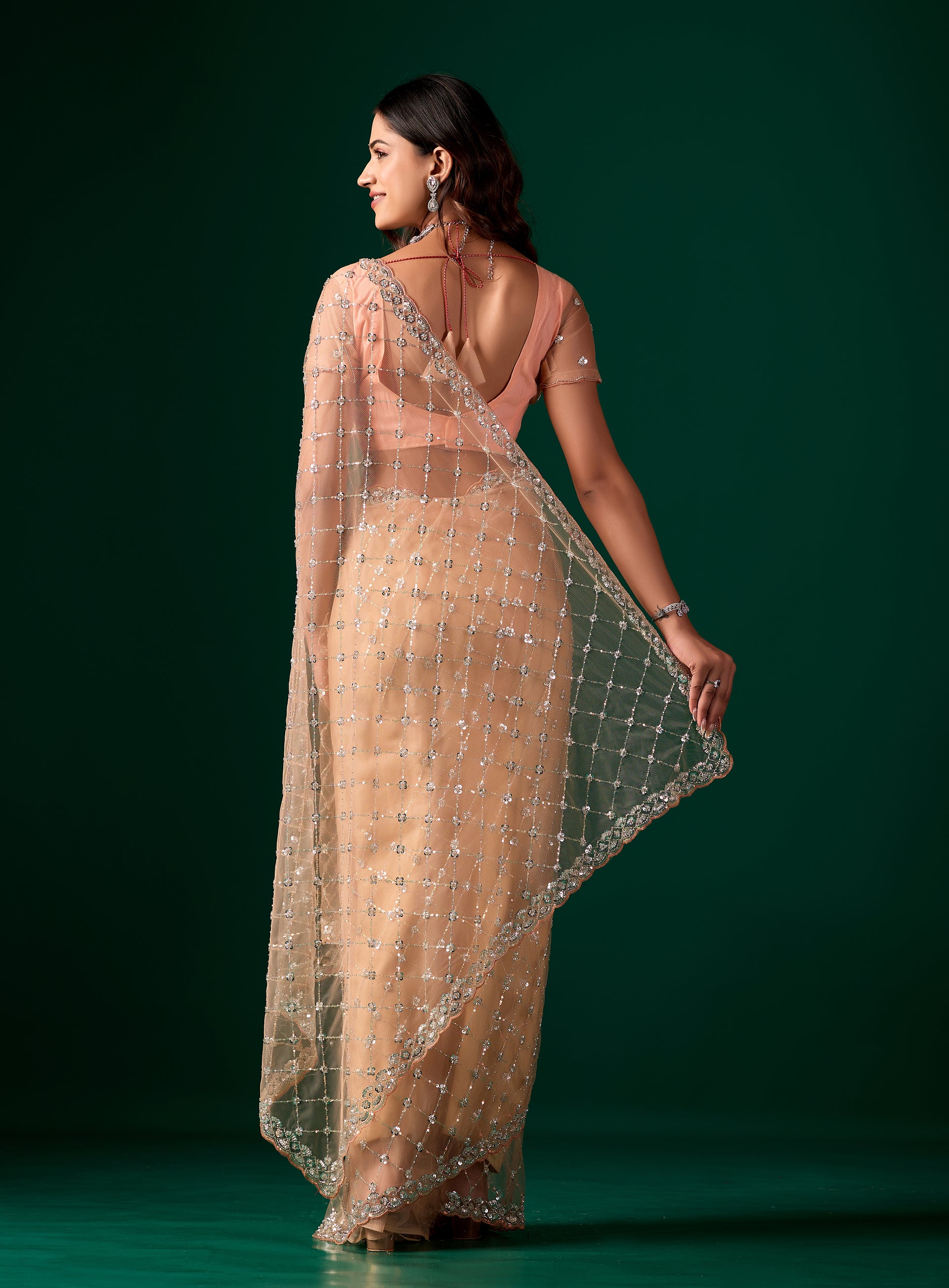 Kanyaari Cross Stylish Orange Net saree with intricate Cutdana work, showcasing elegant drape and detailed embroidery.