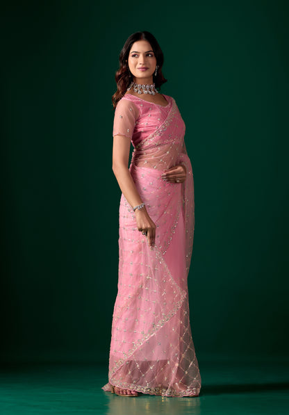 Pink party wear saree with intricate cutdana work by Kanyaari, showcasing elegant draping and detailed embroidery.