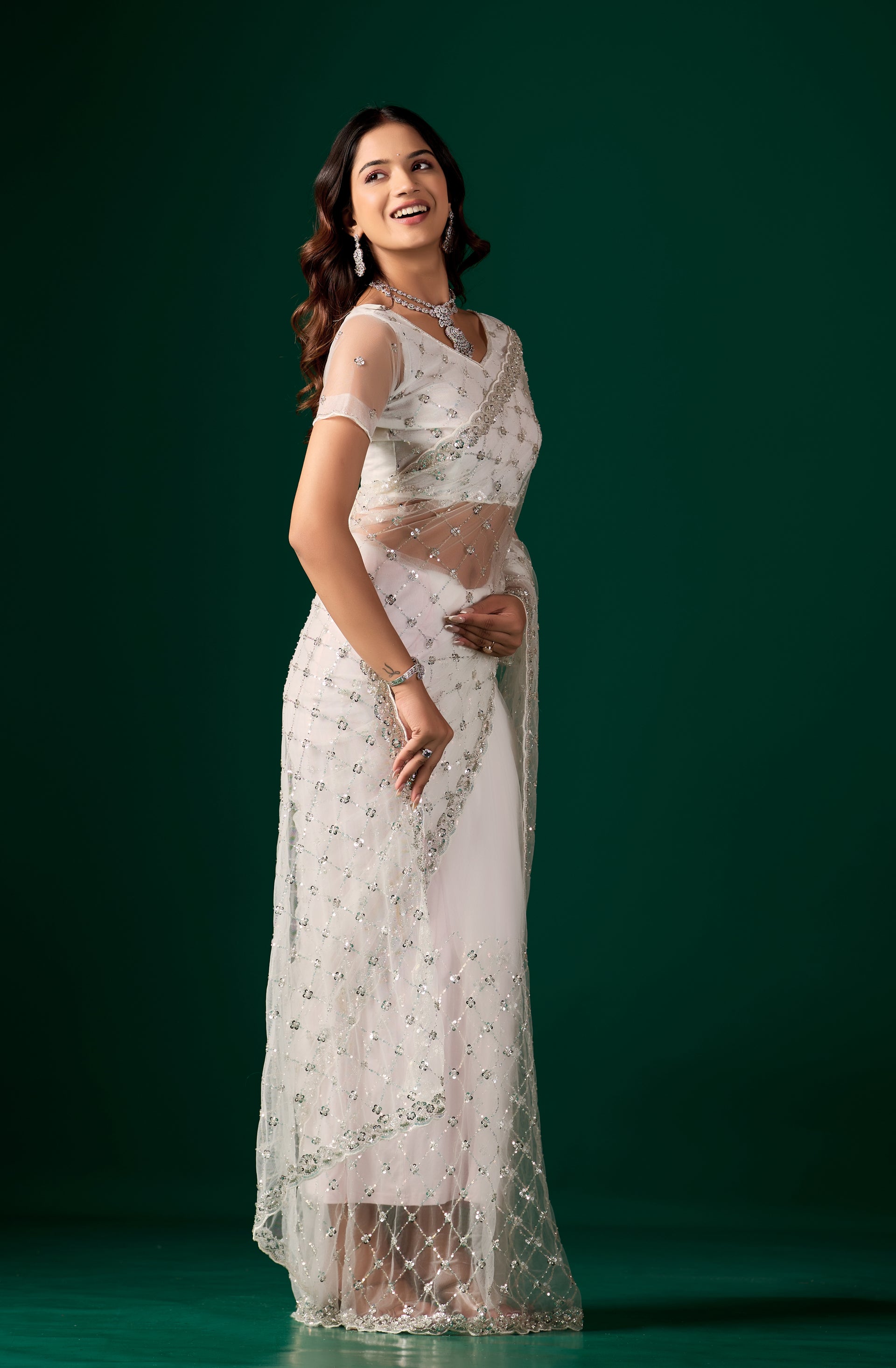 Elegant white party saree with cutdana and sequence work by Kanyaari, featuring intricate embroidery and draped fabric.
