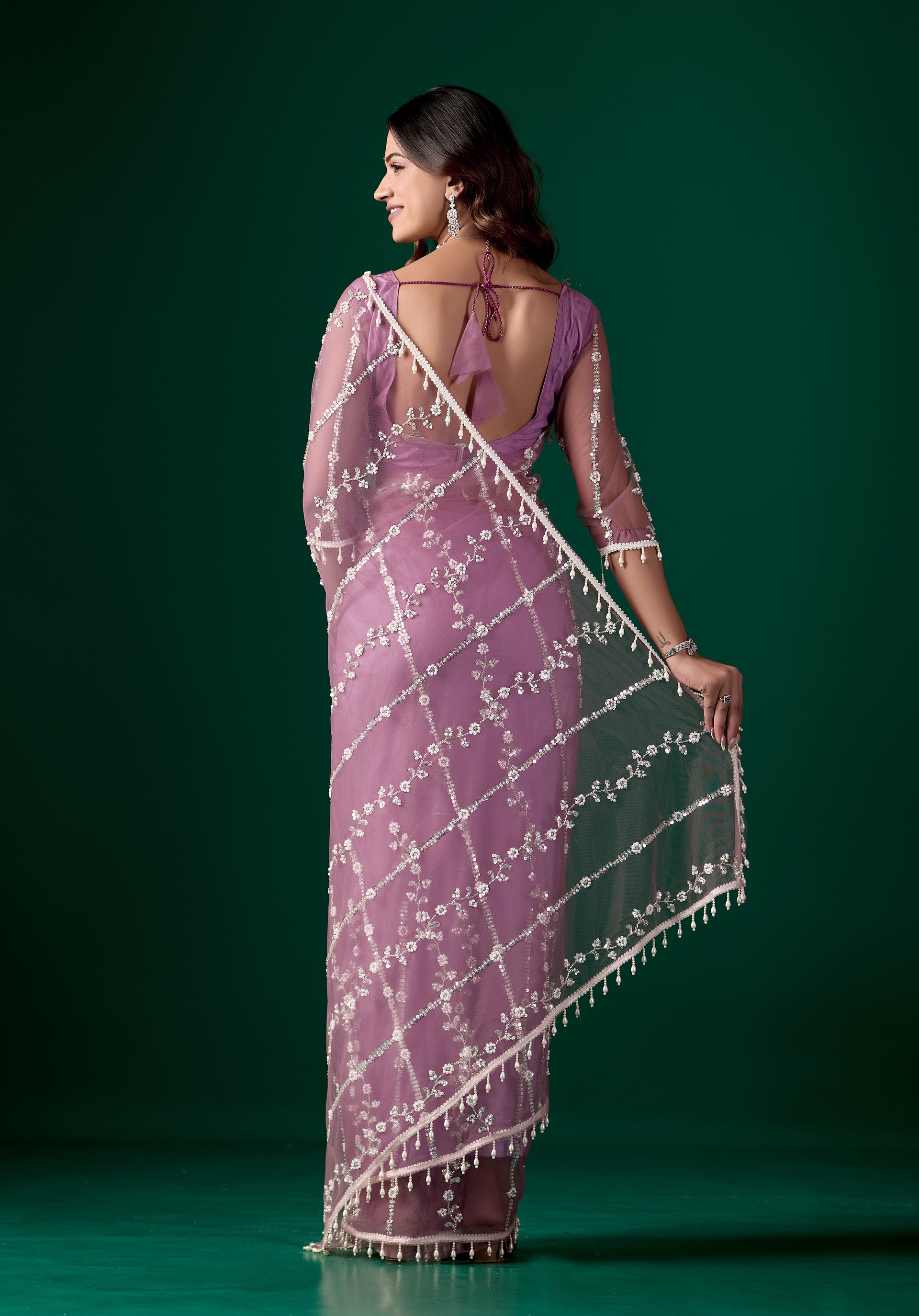 Purple net saree with intricate cutdana work by Kanyaari, featuring elegant drape and detailed embellishments.