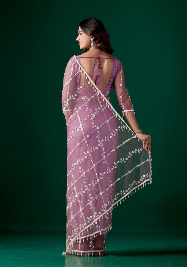 Purple net saree with intricate cutdana work by Kanyaari, featuring elegant drape and detailed embellishments.