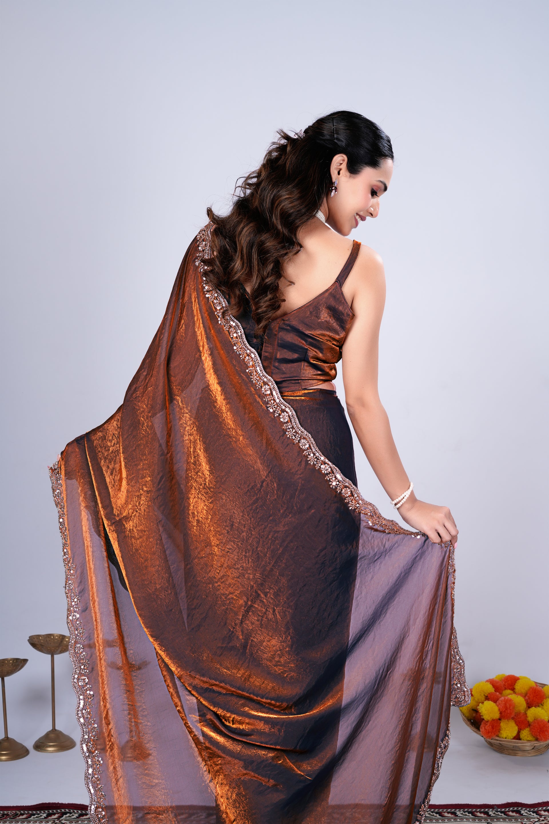 Kanyaari Kriti stylish brown saree with intricate cutdana work, showcasing elegant draping and detailed embroidery.
