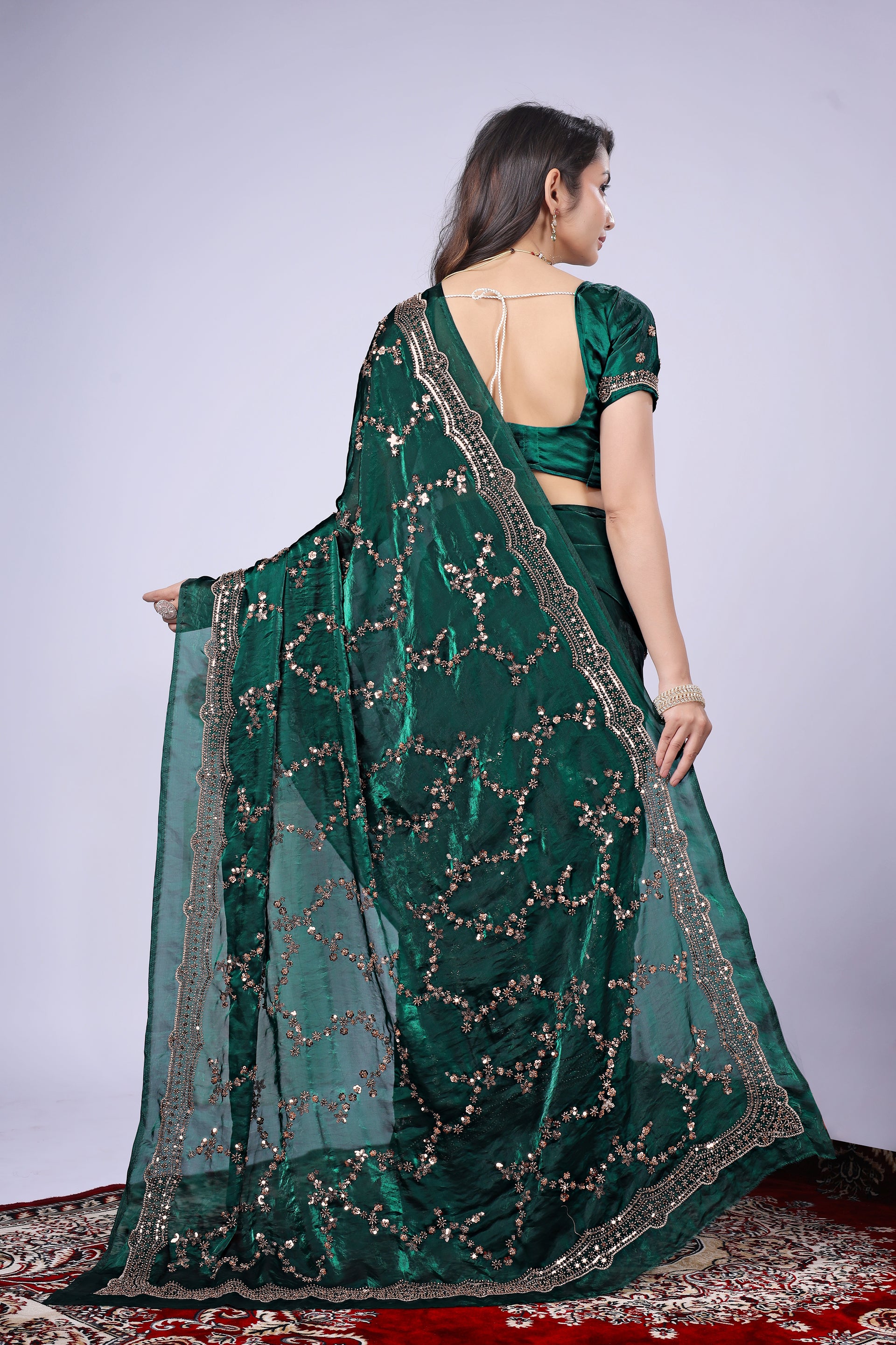 Dark green silk saree with rose gold cutdana work by Kanyaari, featuring intricate embroidery and elegant drape.