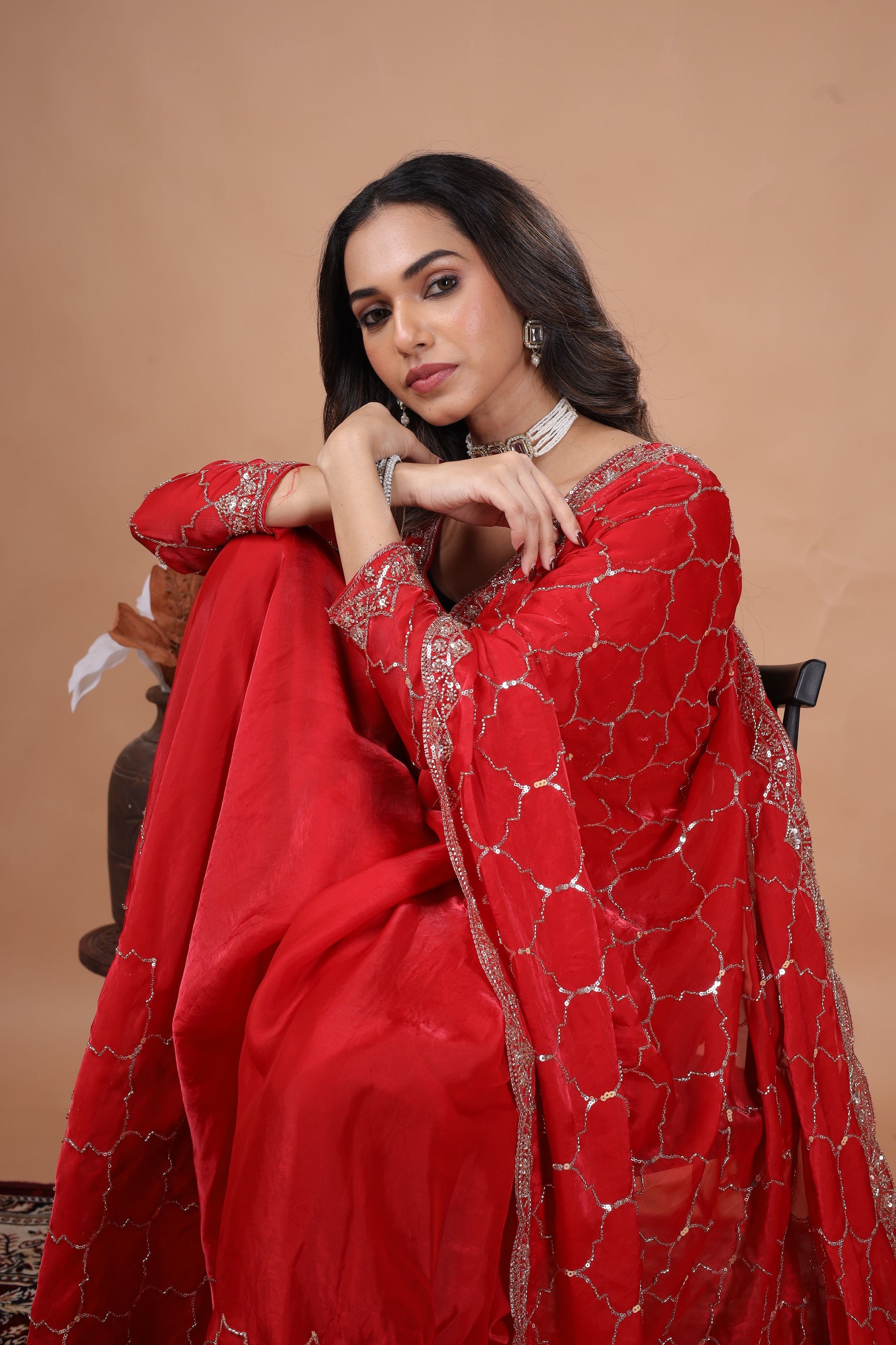 Red silk saree with rose gold cutdana work by Kanyaari, featuring intricate embroidery and elegant draping.