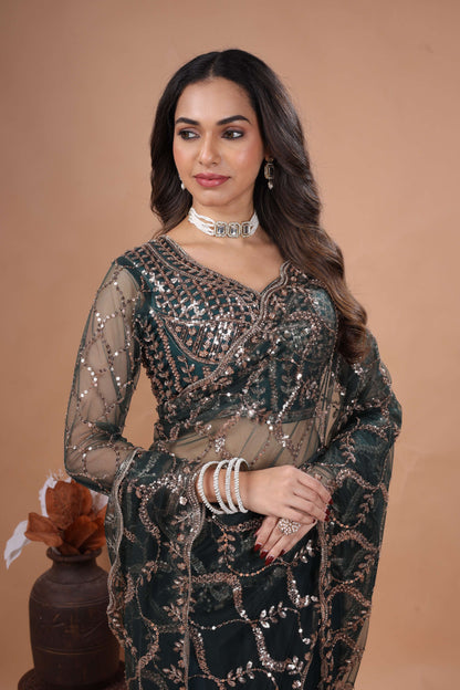 Green net saree with heavy cutdana work border by Kanyaari, showcasing intricate embroidery and elegant drape.