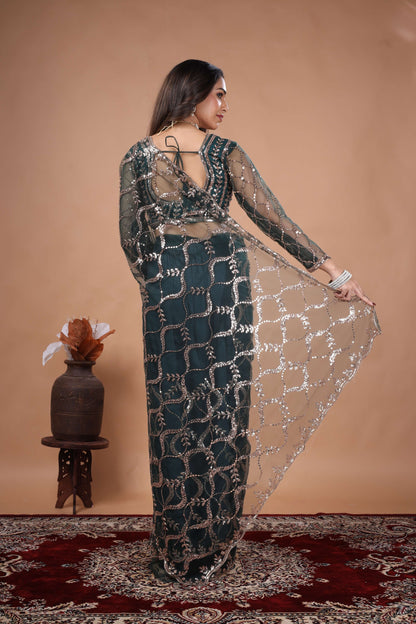 Green net saree with heavy cutdana work border by Kanyaari, showcasing intricate embroidery and elegant drape.