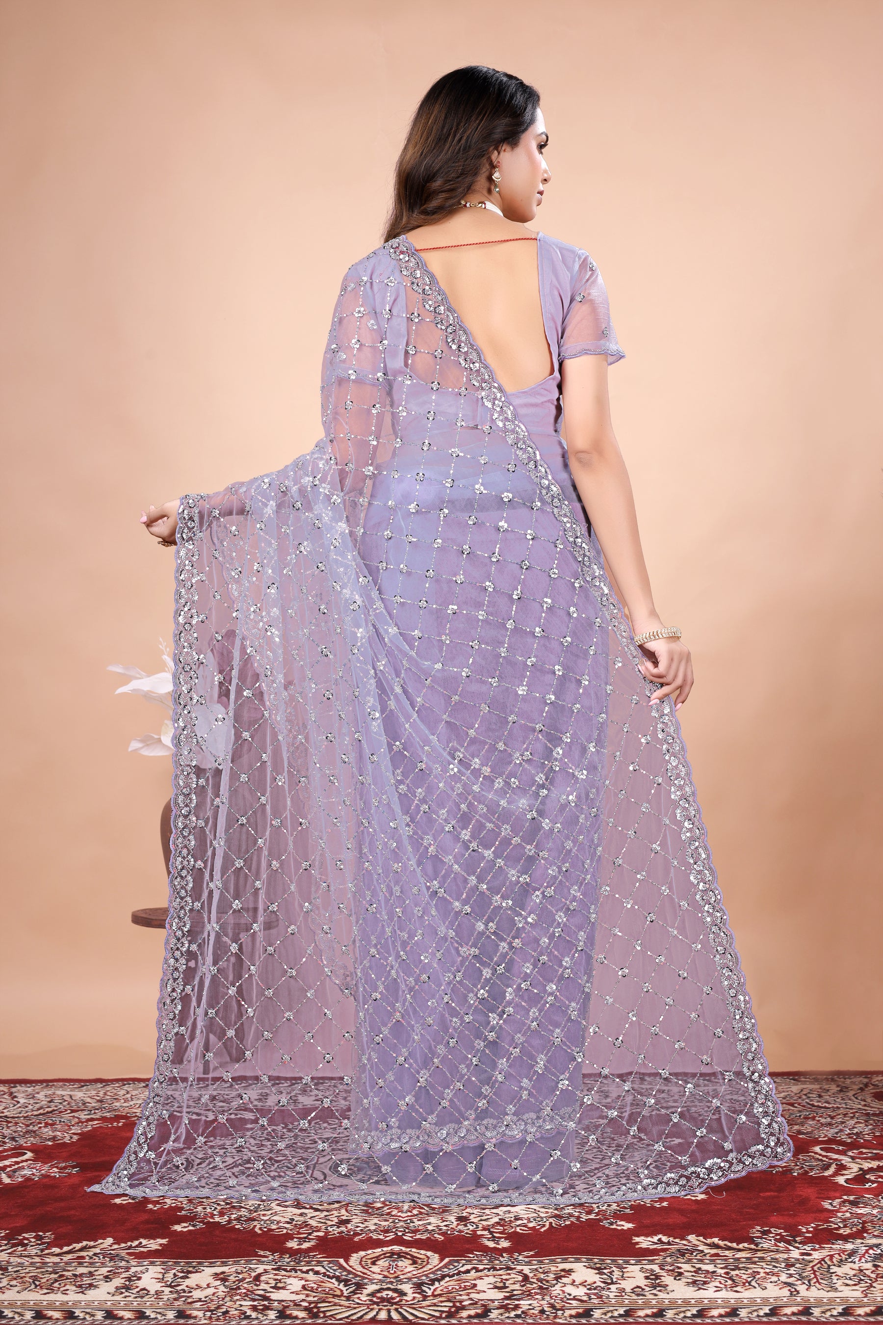 Kanyaari green net saree with cutdana work, stylish cross design, draped on a mannequin showcasing intricate embroidery and fabric texture.