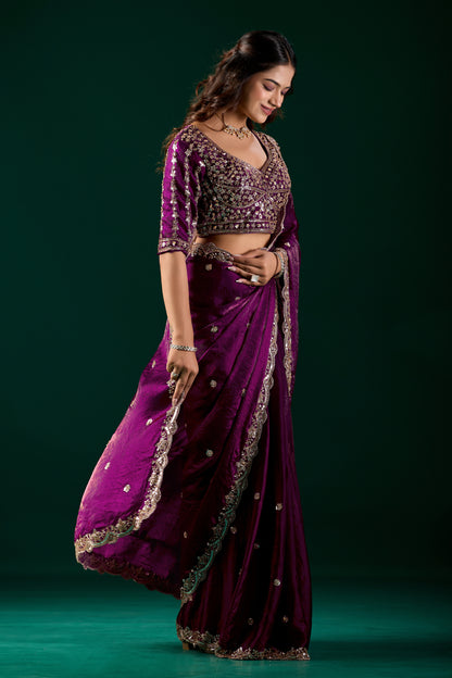 Wine-colored heavy saree with cutdana work by Kanyaari, featuring intricate embroidery and traditional drape.