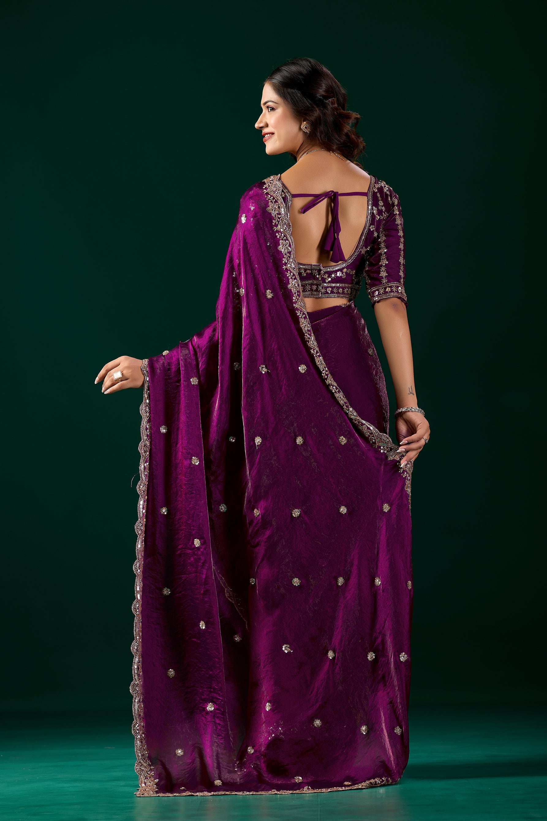 Elegant wine-colored saree with heavy cutdana work by Kanyaari, featuring intricate embroidery and traditional draping.